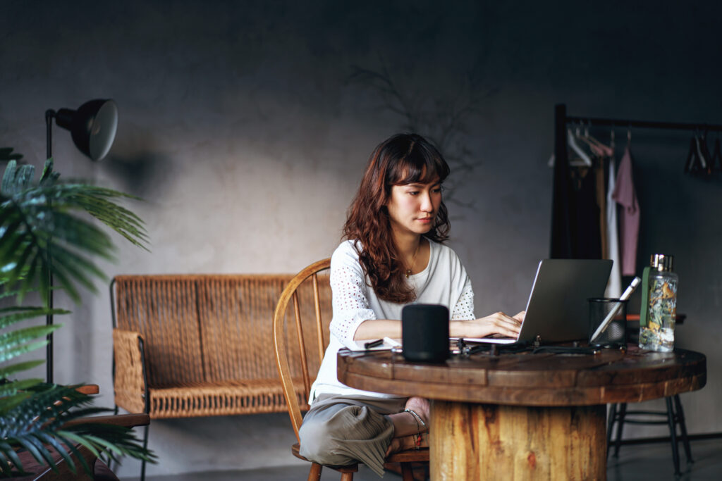 asian woman work from home with smart speaker for assistance