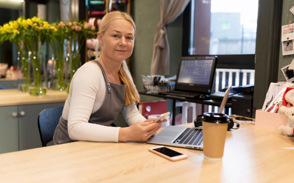 woman sitting at desk with a laptop and phone