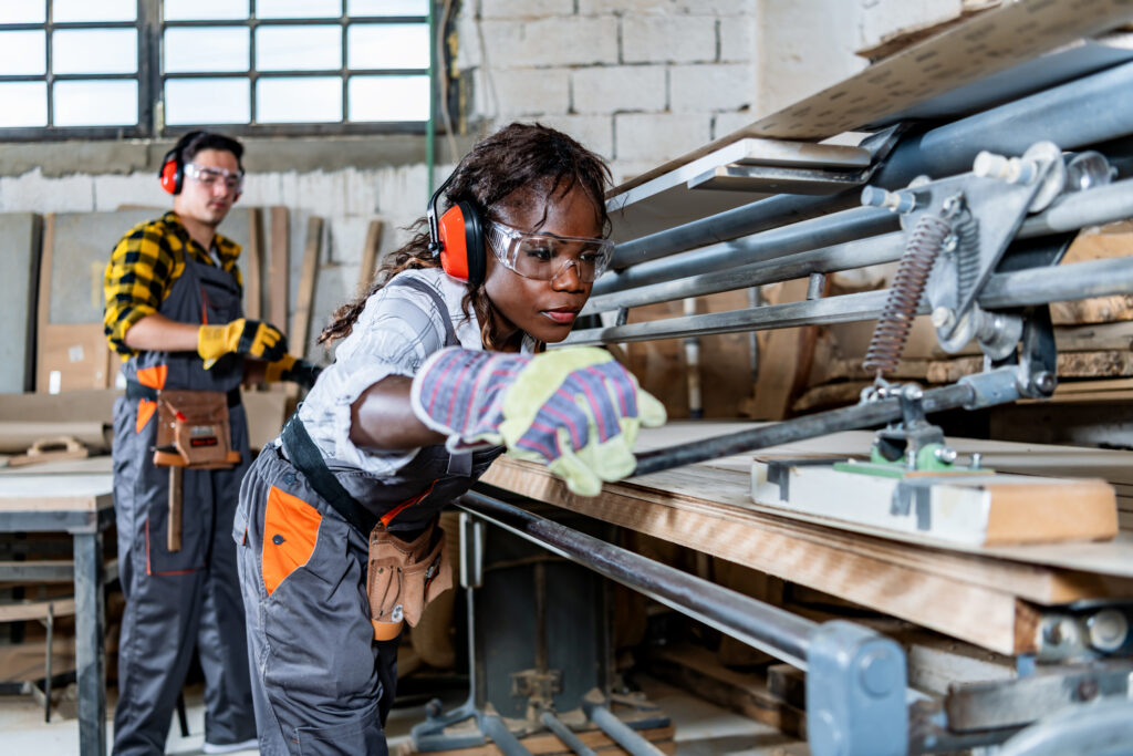 woman in a manufacturing environment, operating heavy machinery