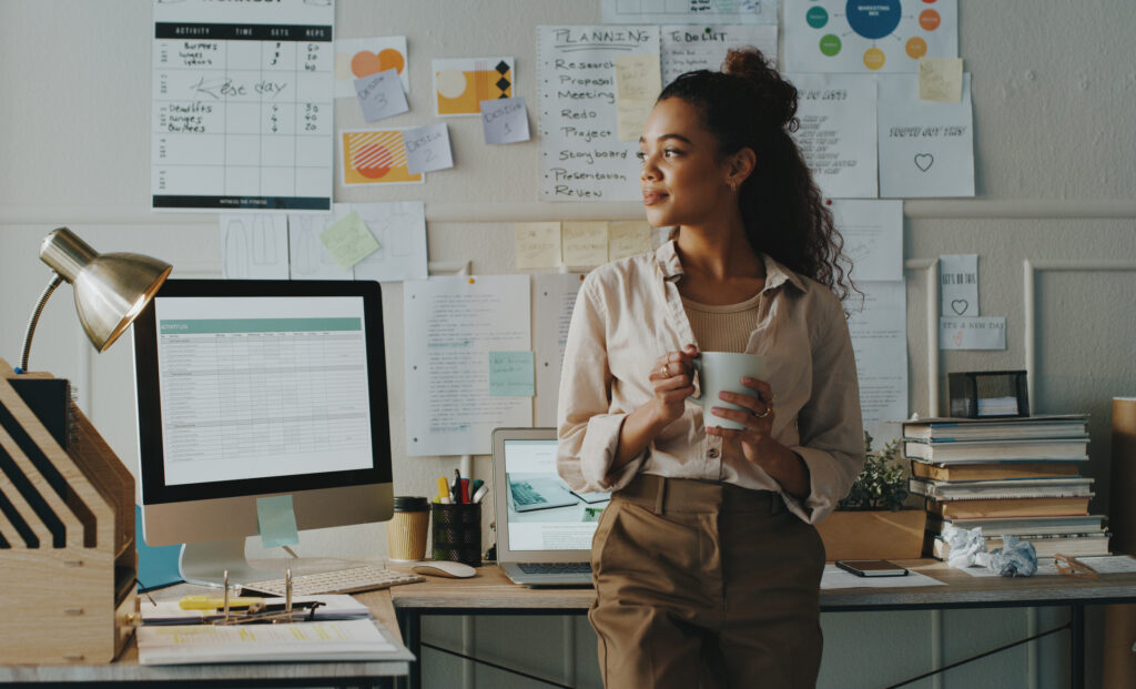 Shot of a young businesswoman holding a cup of coffee in her home office