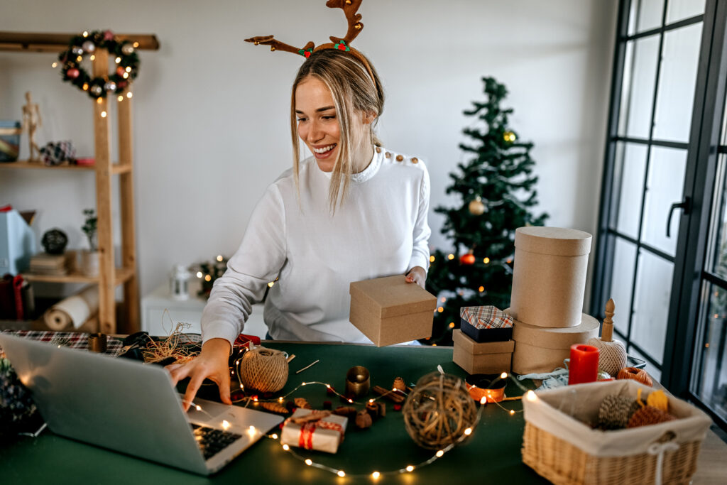 Young woman working at online shop, she checking address of customer and package information on laptop.